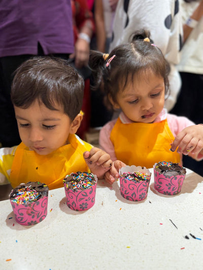 Toddlers decorating cupcakes