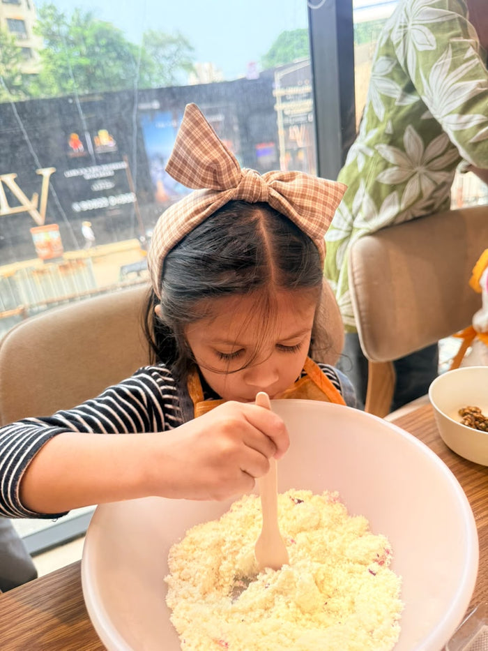 A little chef mixing her modak dough at Foodstories
