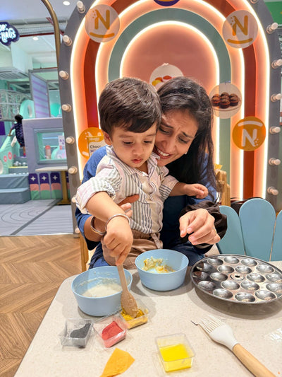 A mother helping her son mix